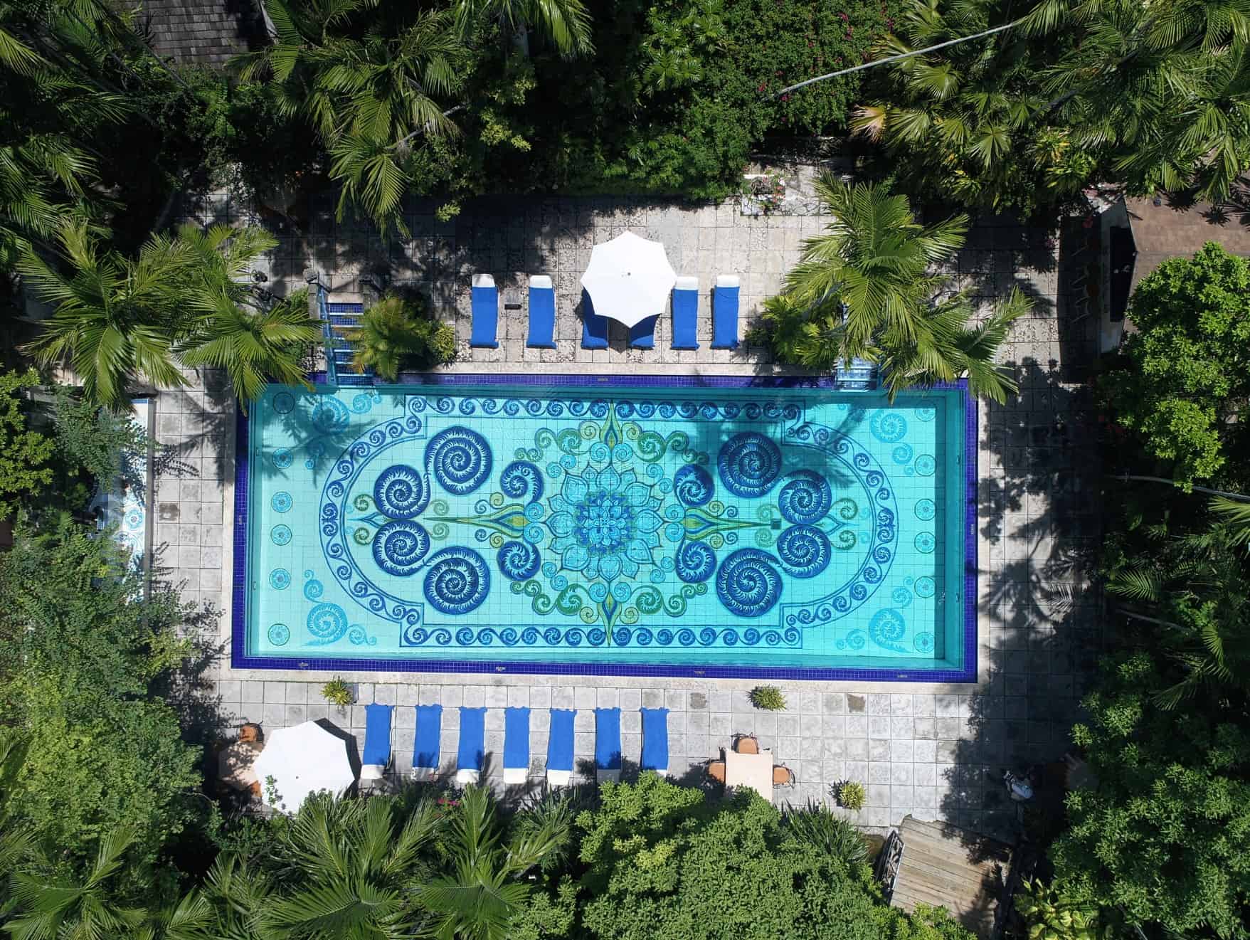 looking down on blue tiled swimming pool from above.