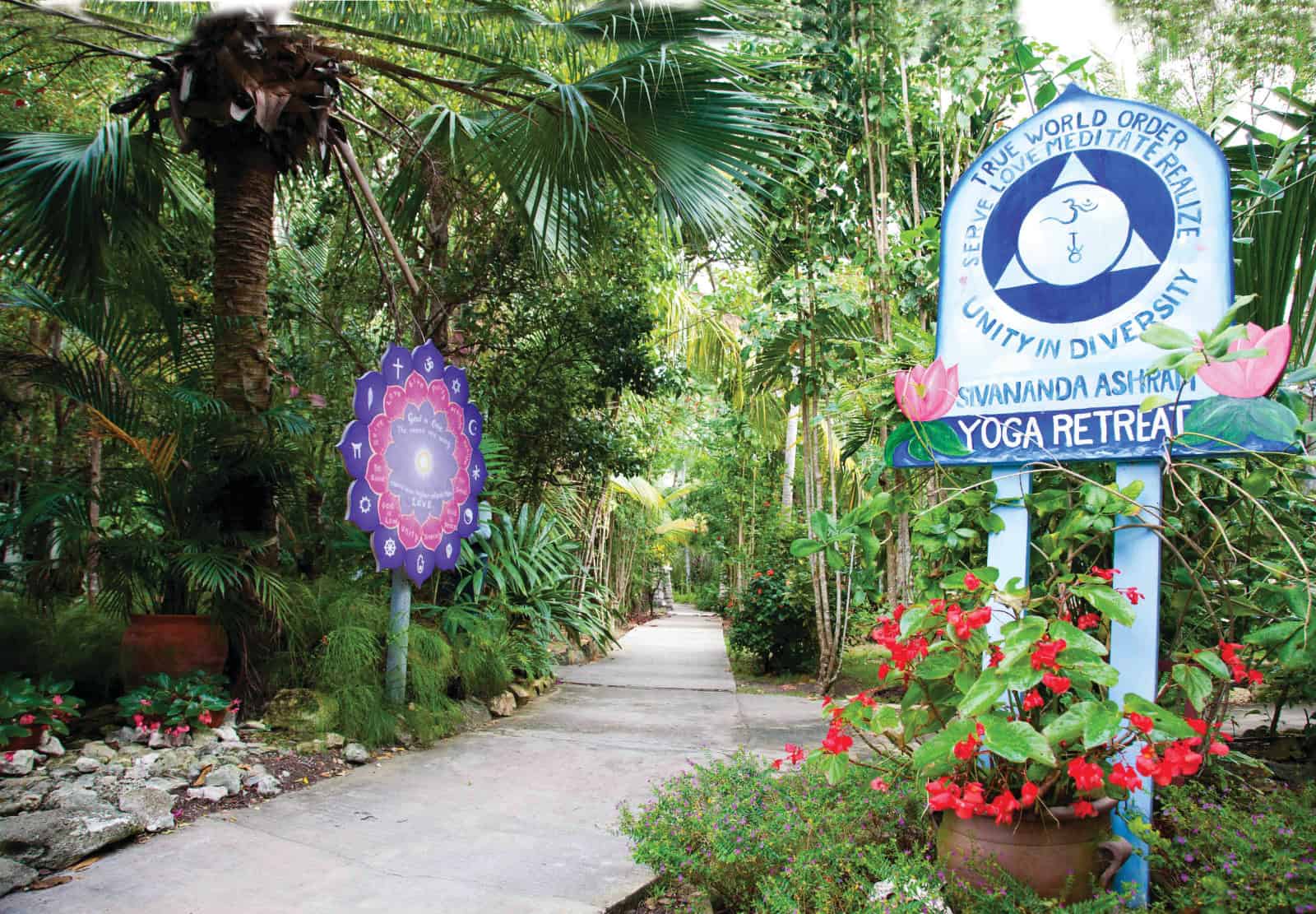 walking path through landscaped resort grounds with a welcome sign on righthand side